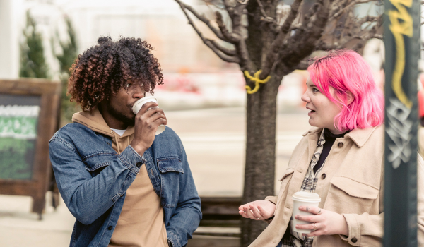 Young students talking drinking coffee pink hair
